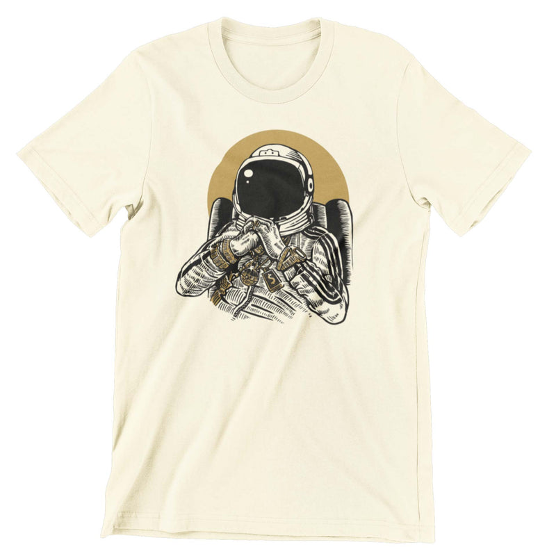 Butter colored t-shirt with a graphic print of an astronaut DJ in a track suit blinged out in gold. He is sitting in a chair with his hands folded.  Edit alt text