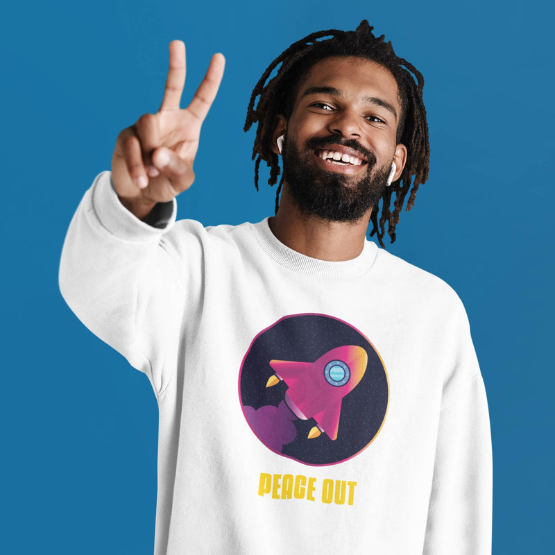 guy wearing white crewneck sweatshirt showing a rocket flying and it says peace out below the rocket.
