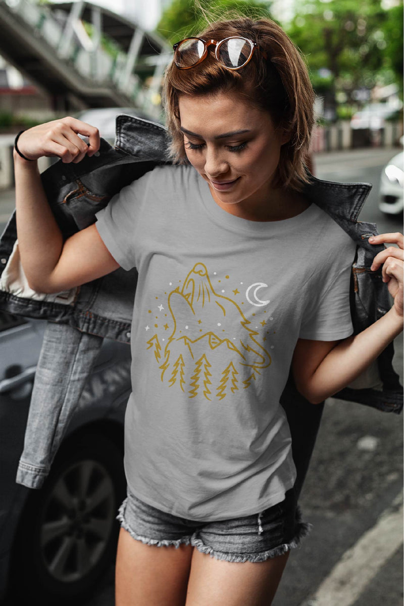 Woman wearing Light Gray short sleeve t-shirt with a print of a wolf's head howling to the night sky.